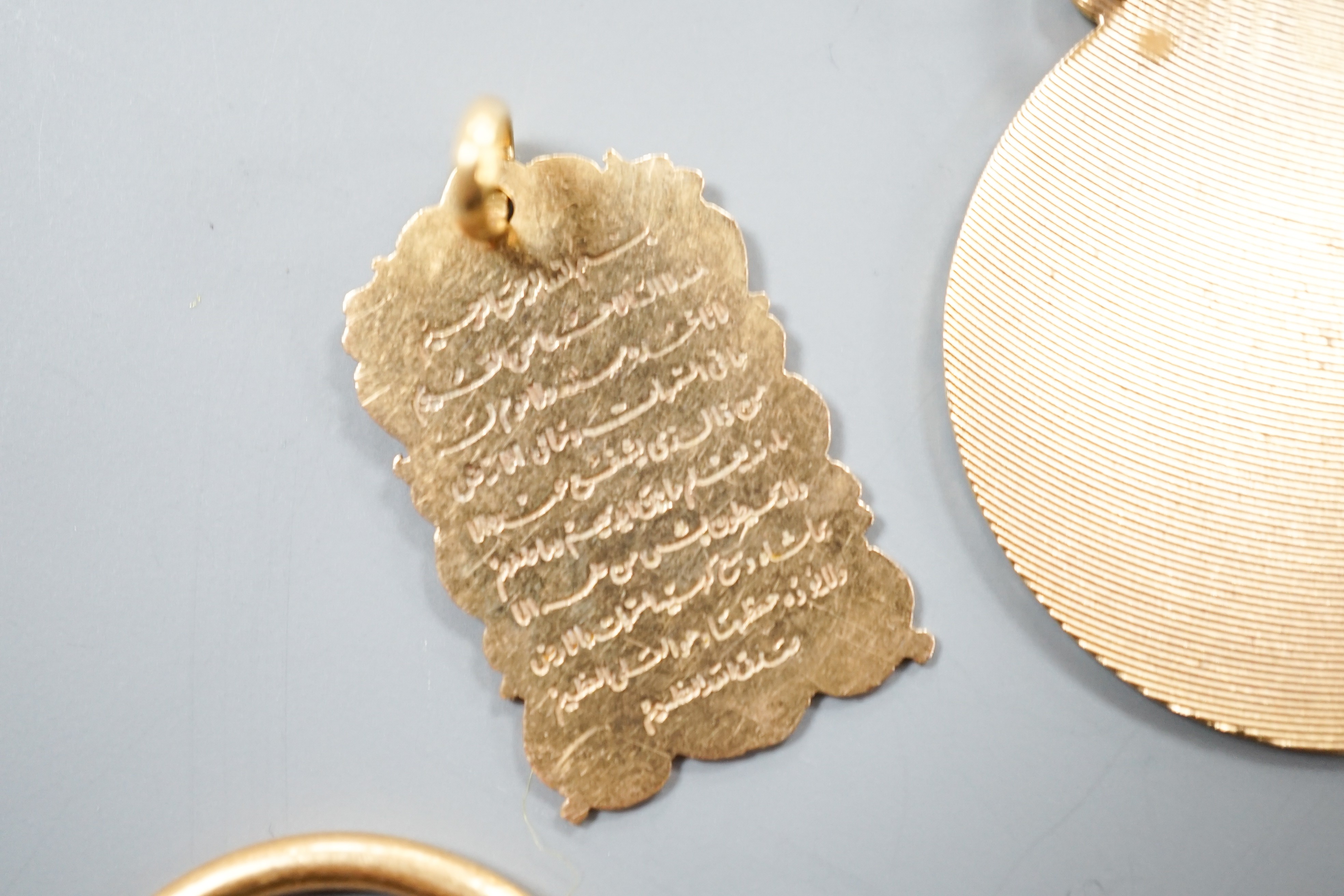 A Middle Eastern yellow metal and enamel pendant on a similar clip and three other Middle eastern pendants, one with chain, gross weight 34.5 grams and an Egyptian scarab.